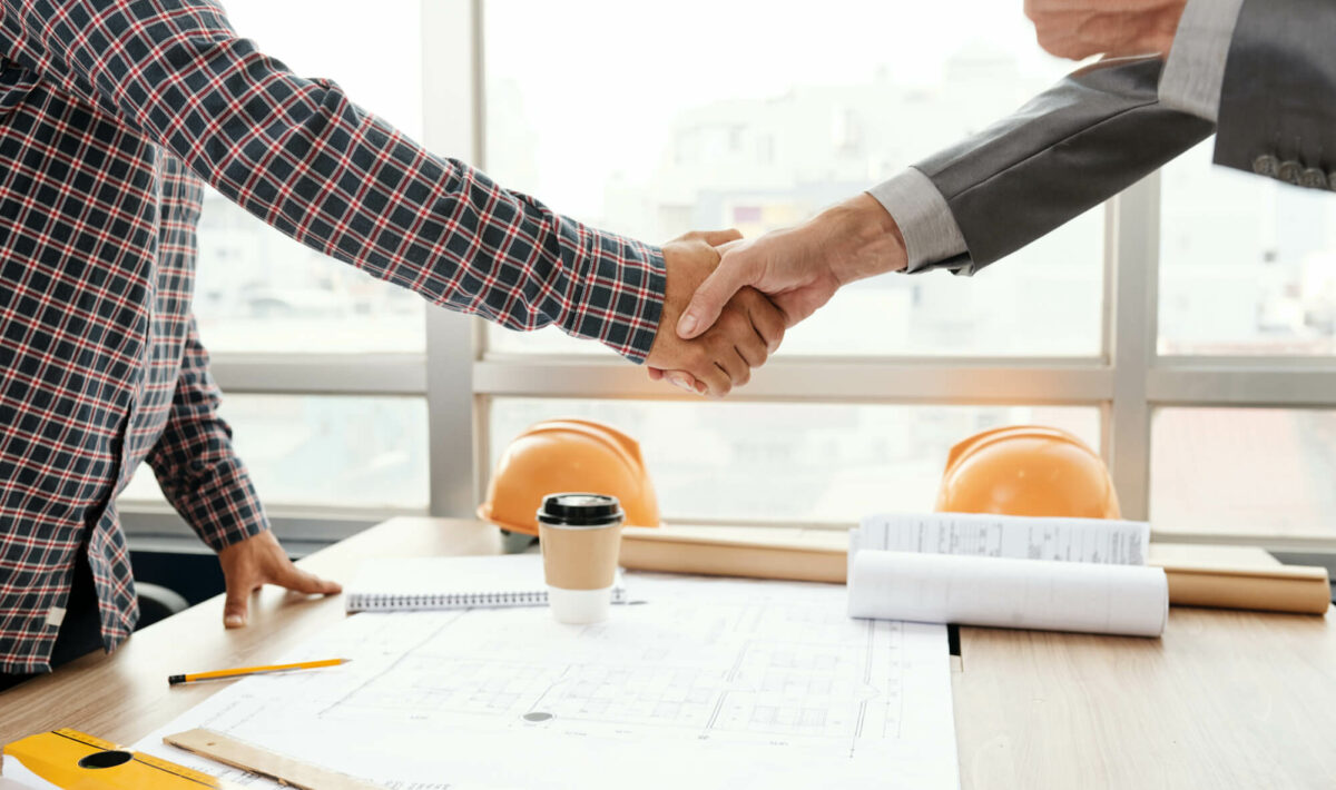 Two business people shaking hands at zumBrunnen, a construction consulting firm