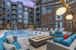 Apartment community pool deck with a fire pit lounge at dusk