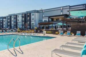 Apartment community pool deck beside a multi-story building