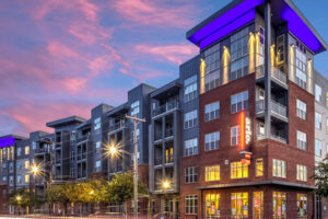 Gray Company apartment building at dusk under a colorful sky