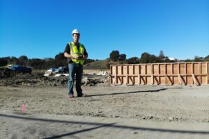 created by dji camera Construction monitor in a safety vest standing on the Enso Village job site for zumBrunnen construction consulting