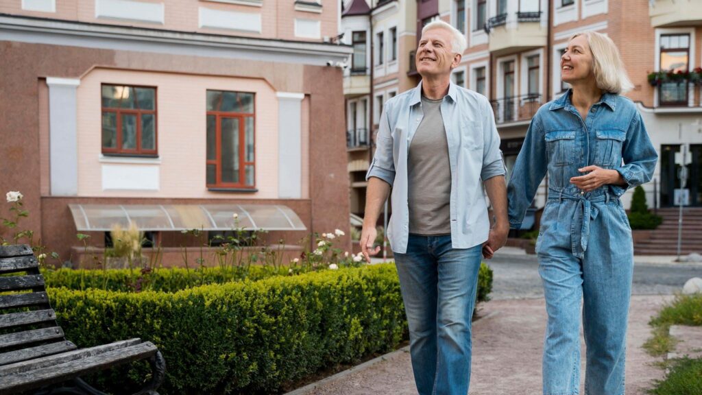 Middle aged man and woman, holding hands, walking through a city street admiring the ambiance
