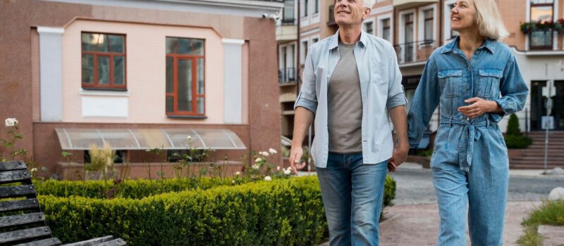Middle aged man and woman, holding hands, walking through a city street admiring the ambiance – construction consulting firm zumBrunnen